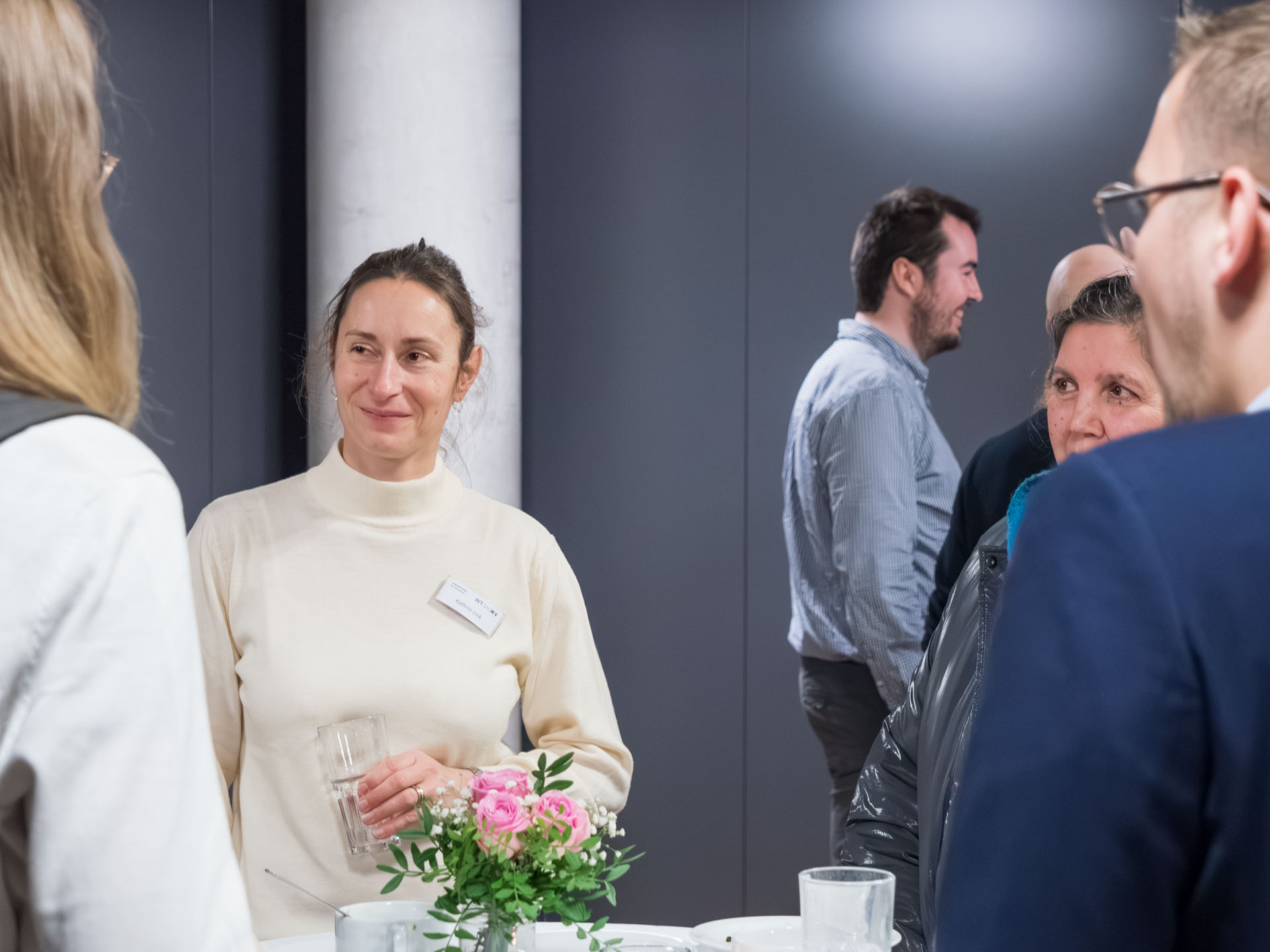Personen an Stehtischen im Gespräch